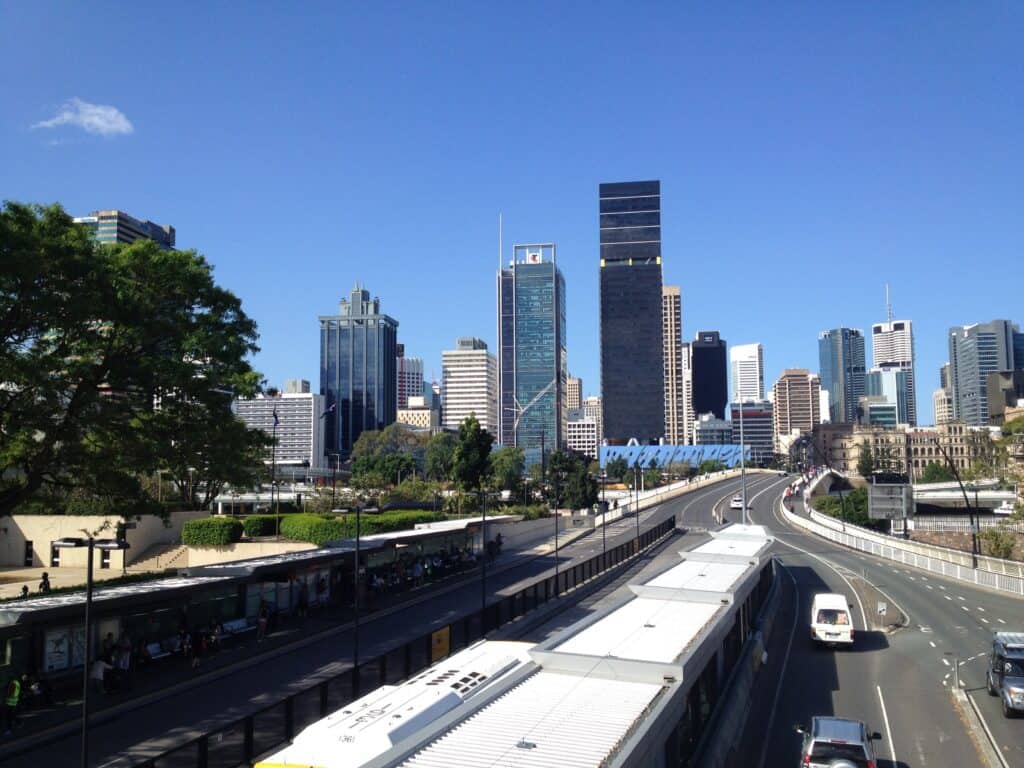 A city street with a bus station and city in background