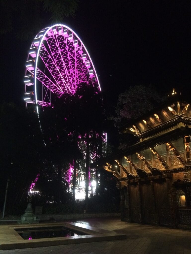 Nepalese padoda and ferris wheel illuminated at night