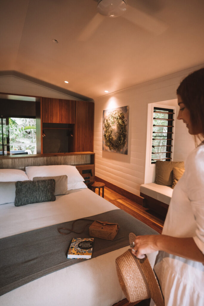 woman placing belongs on hotel room bed