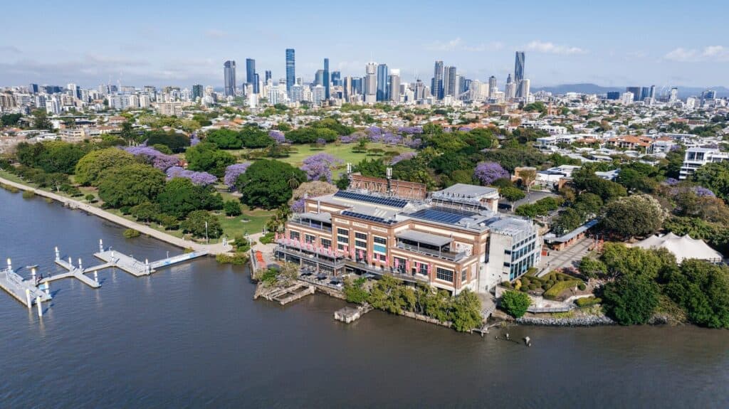 aerial view of converted warehouse and lush botanical gardens by a river