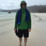 man standing in rain jacket on beach during rain