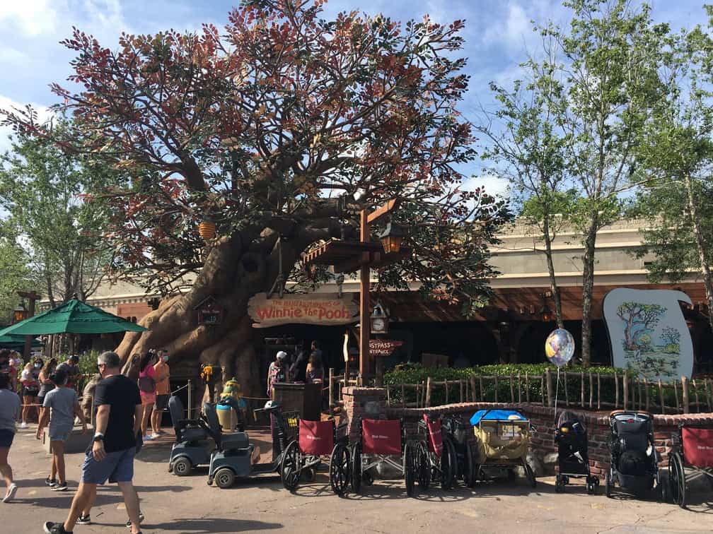 strollers and wheelchairs lined up outside the entrance of Winnie the Pooh ride at Disney